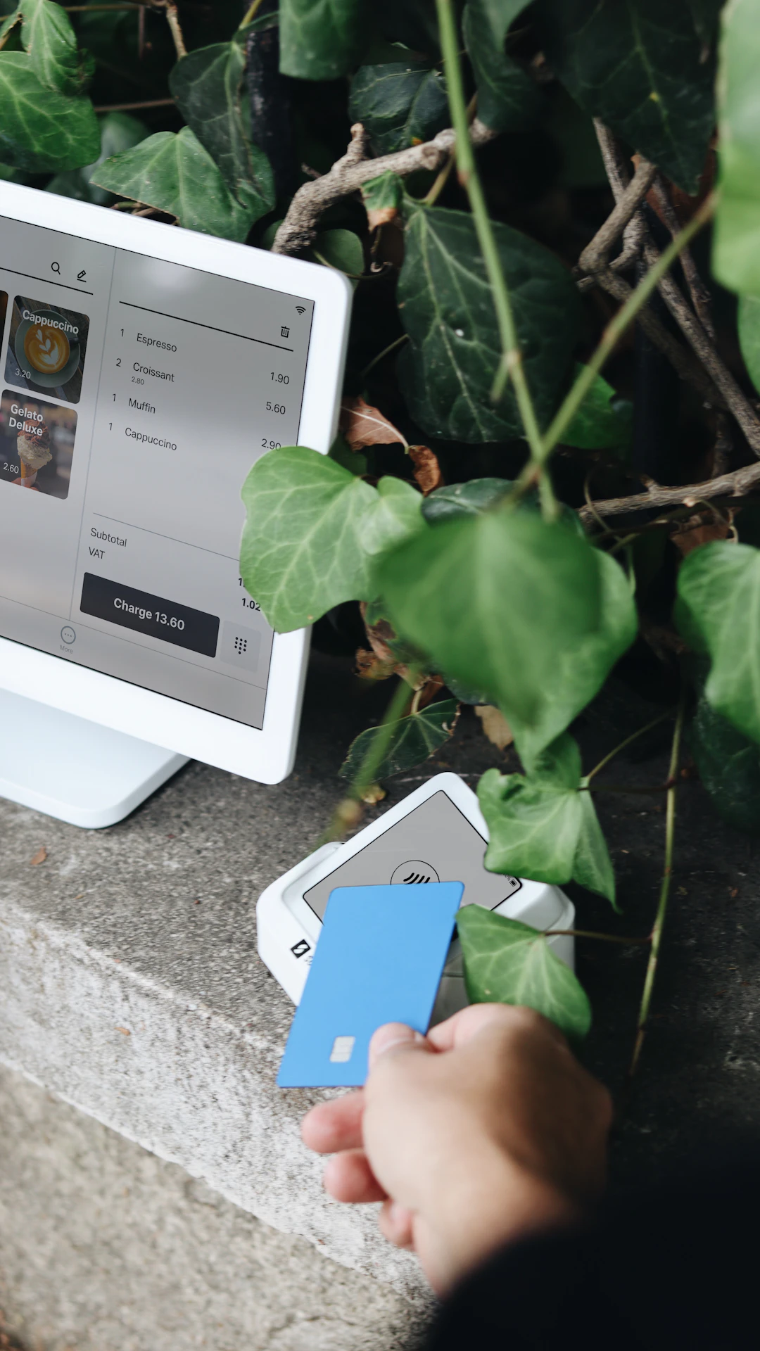 A person holding a credit card next to a computer