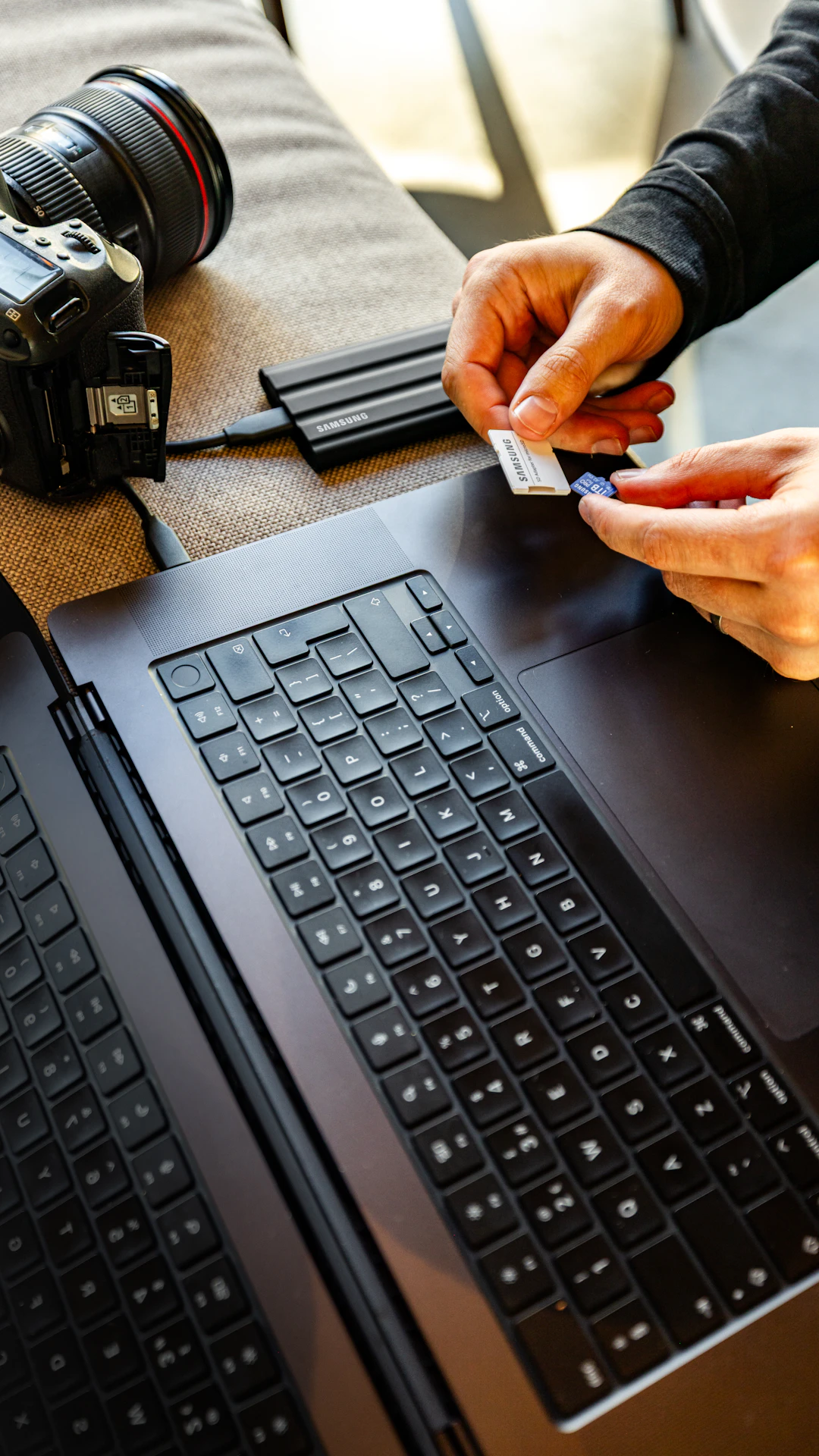 Hands inserting sd card into laptop reader