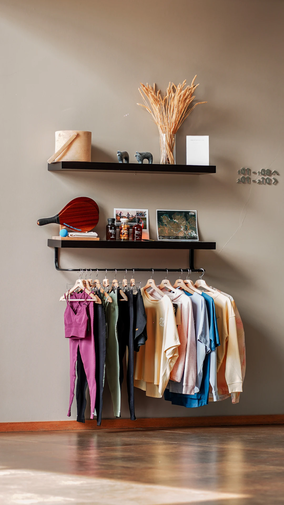 a rack with clothes and a vase on a shelf