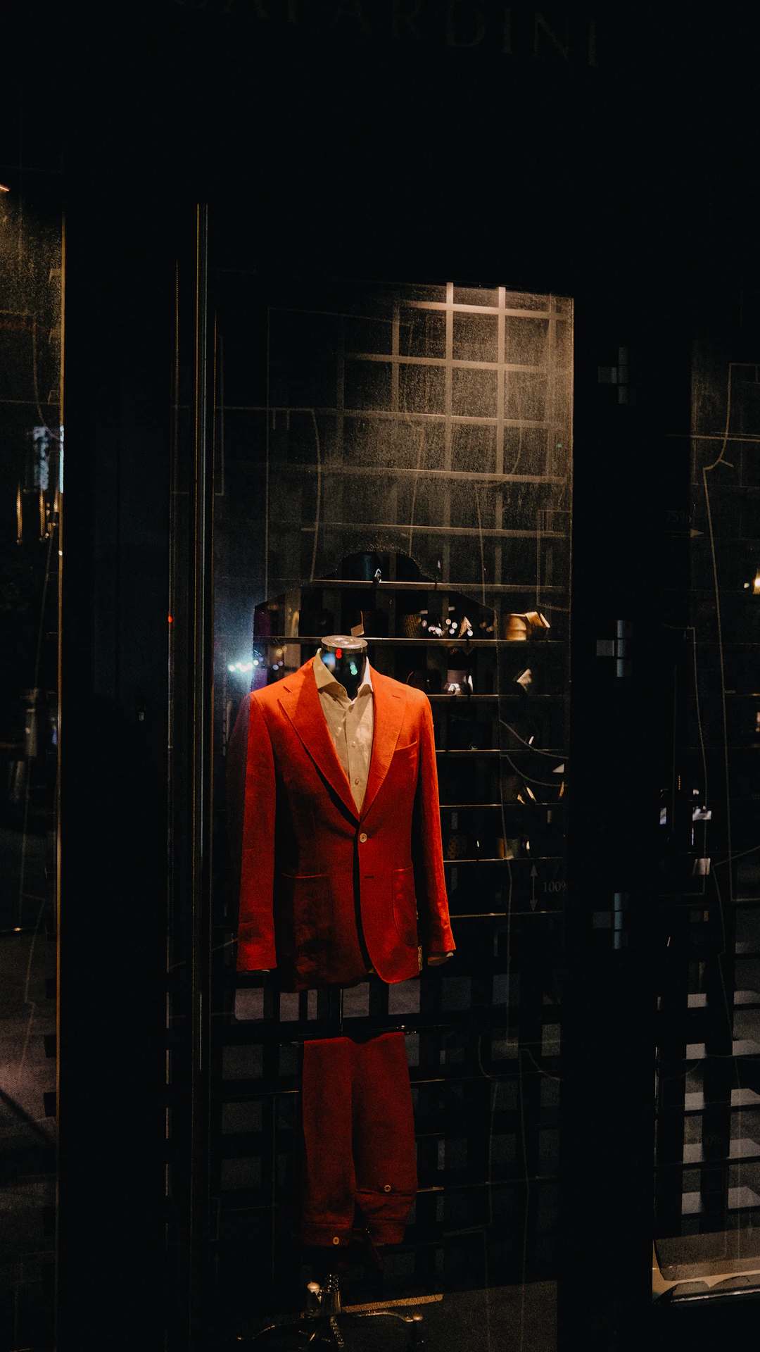 A display case with a red suit and white shirt