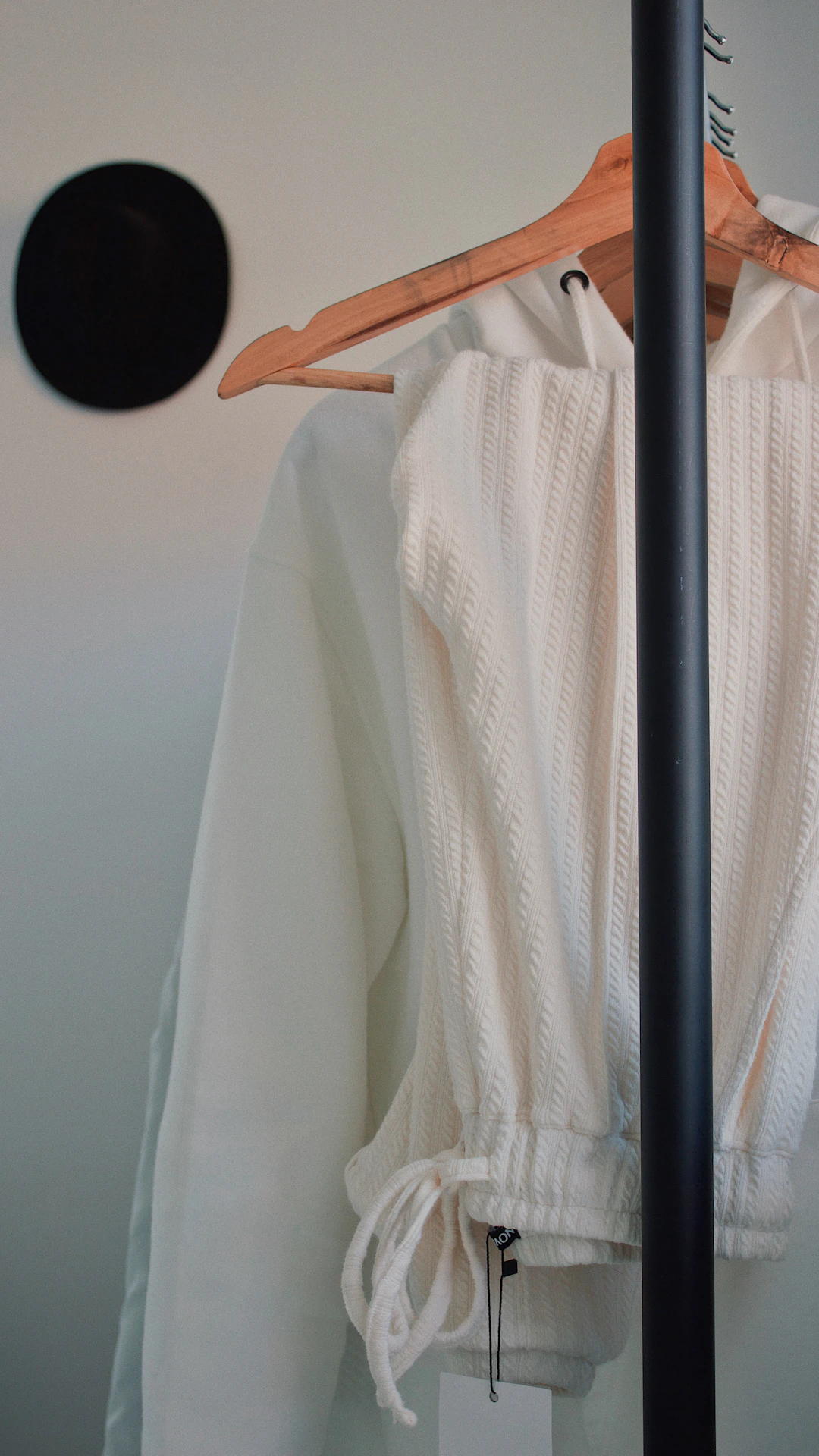 white drawstring jeans and hoodie on hanger