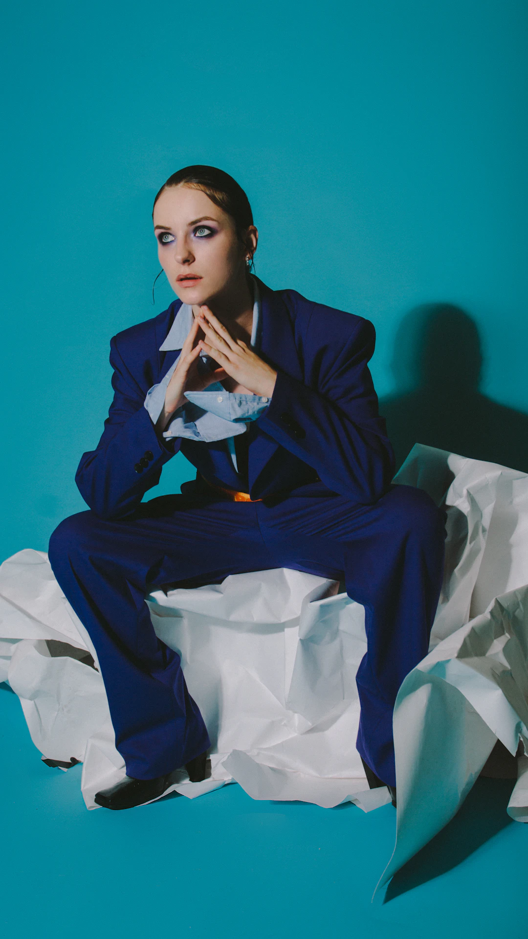 woman in black blazer sitting on bed