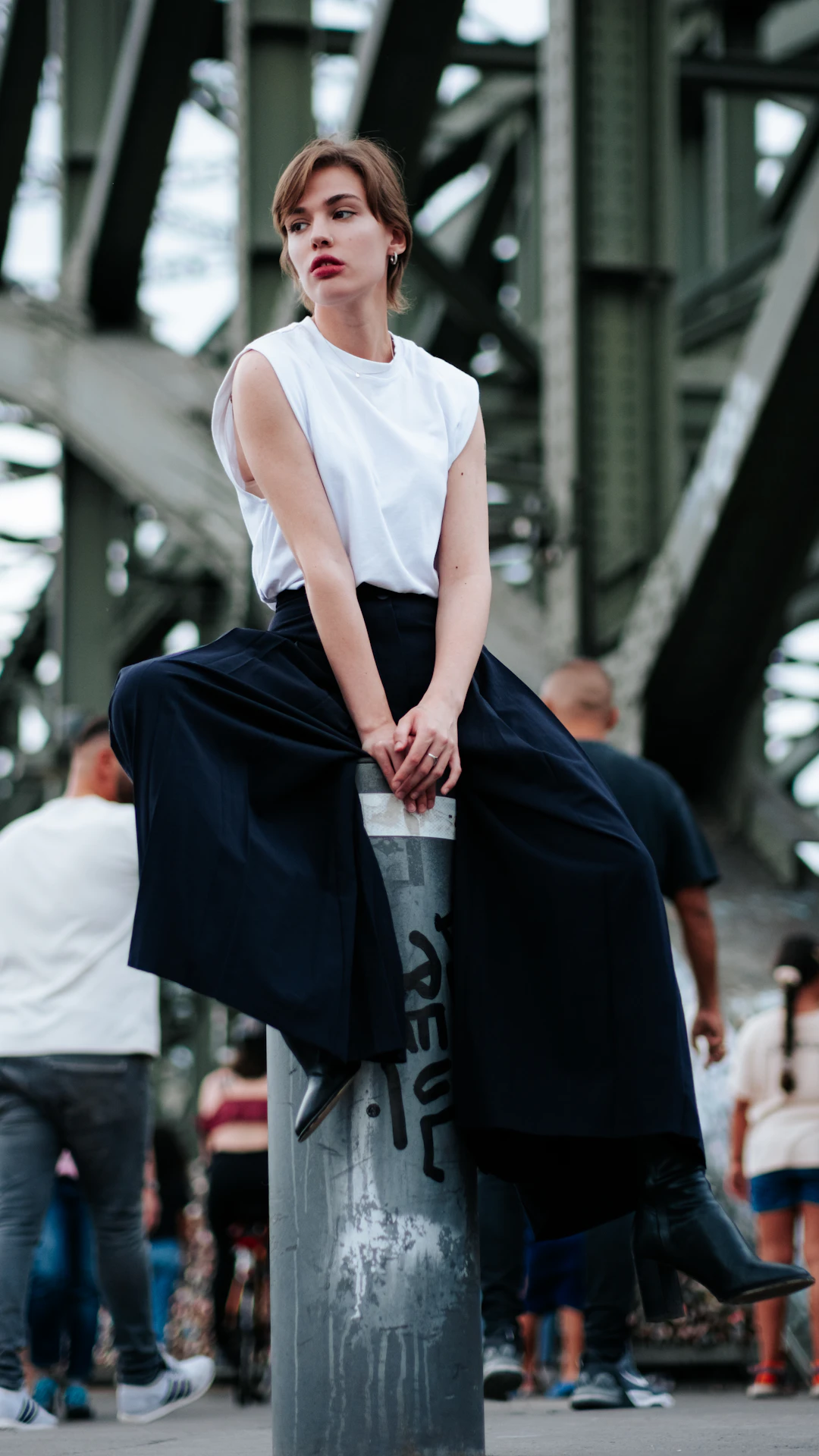 A woman is sitting on top of a pole