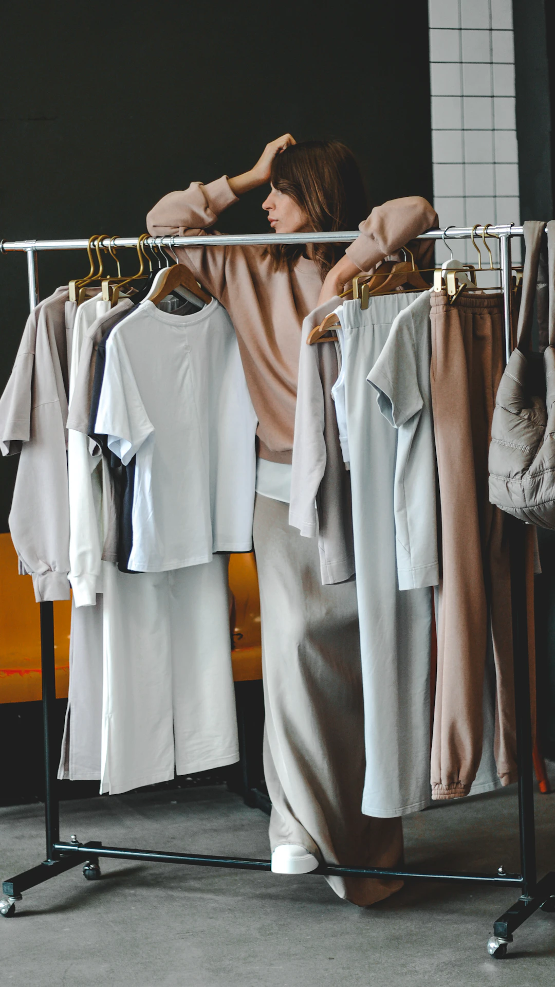 Woman browses clothes on a rack, choosing an outfit.