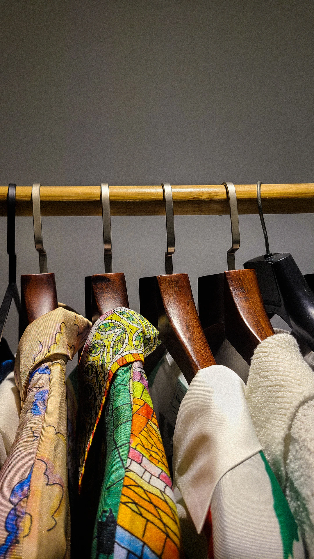 Clothes hang neatly on a wooden rail.