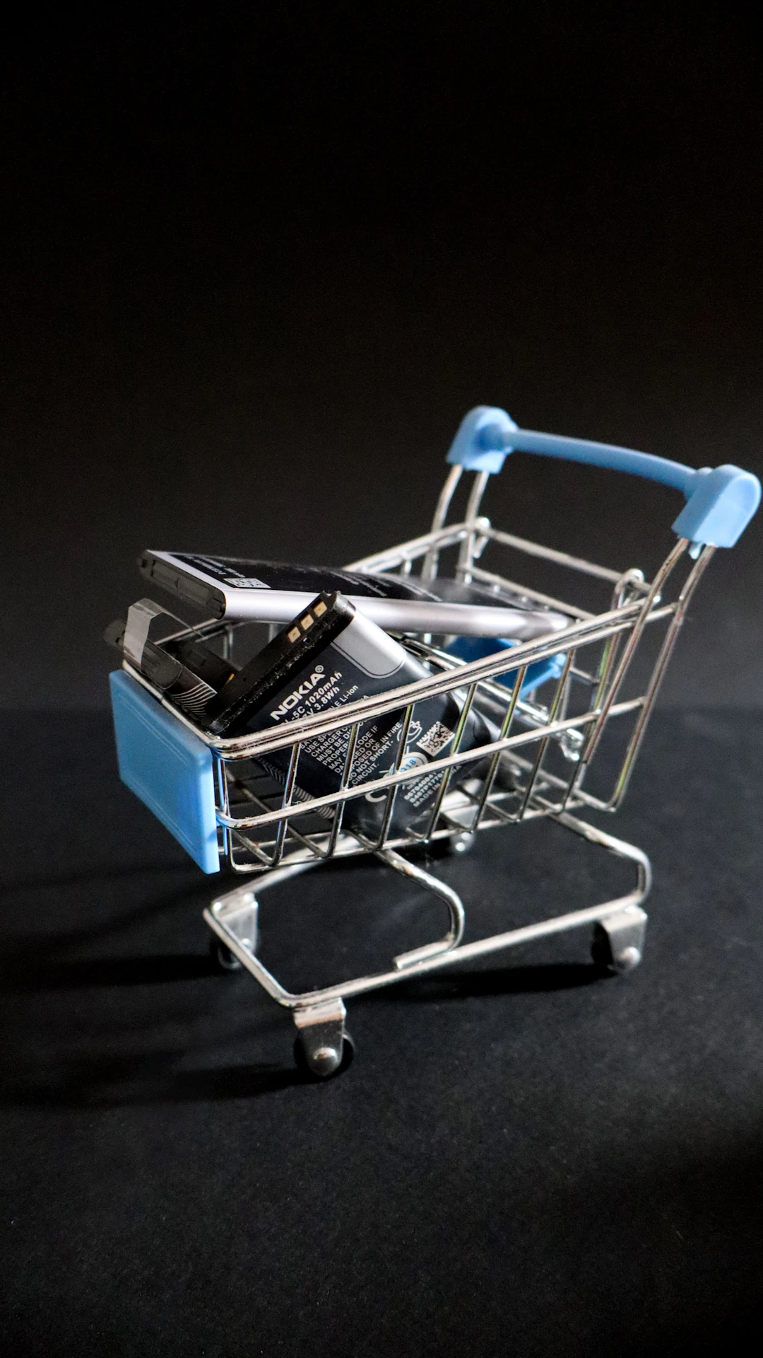 A miniature shopping cart with a cell phone in it